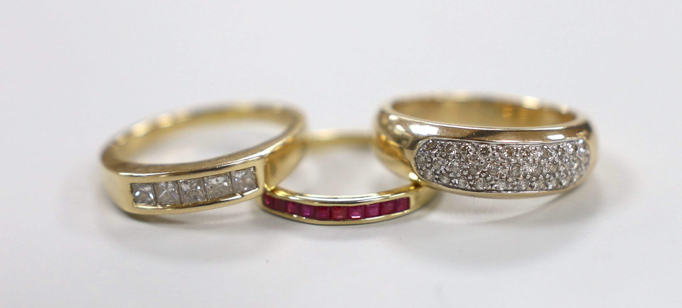 A modern 14k and five stone channel set princess cut diamond set half hoop ring, size Q/R, gross weight 5.3 grams and two modern 9ct gold and gem set rings including pave set diamond, gross weight 7.8 grams.
